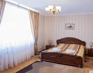 a bedroom with a bed and a large window at Hotel&Restaurant SENATOR in Truskavets