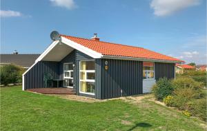 a black and white shed with an orange roof at Friedrichskoog-Strandpark 15 in Friedrichskoog
