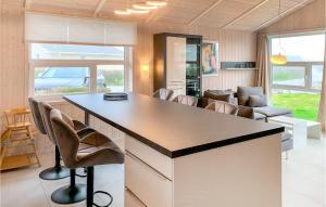 a kitchen with a large island in a room with chairs at Friedrichskoog-Strandpark 15 in Friedrichskoog +19 photos