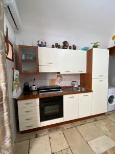 a kitchen with white cabinets and a stove top oven at Home Sweet Home rooms in Bari