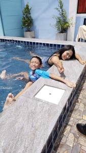 twee kinderen zwemmen in een zwembad bij Khao thalu guest house in Ban Muang Wan