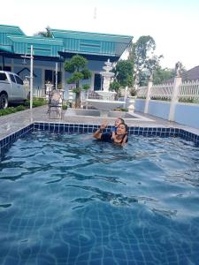een jonge jongen die zwemt in een zwembad bij Khao thalu guest house in Ban Muang Wan