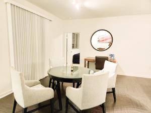 uma sala de jantar com uma mesa, cadeiras e um espelho em Cityscape Luxury Rental Homes in the Heart of Los Angeles em Los Angeles