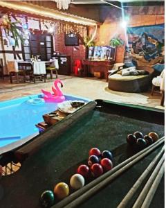 una mesa de billar con pelotas en una piscina en Casarão Refugio da Serra Suites,4km do Baden Baden, en Campos do Jordão