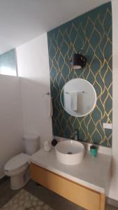 La salle de bains est pourvue d'un lavabo, de toilettes et d'un miroir. dans l'établissement CASa SENECA, à La Paz