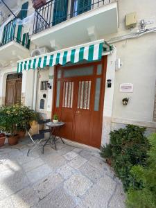 a building with a brown door with a green and white awning at Home Sweet Home rooms in Bari