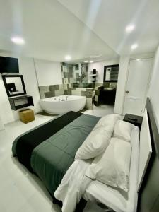 een slaapkamer met een groot bed en een bad bij Cozy Suite near hotsprings waterfall of Baños Ecu in Baños