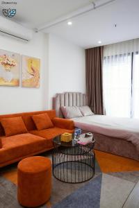 un salon avec un canapé et un lit dans l'établissement Homestay-Vinhomes Smartcity-Căn hộ dich vụ, à Thượng Thôn