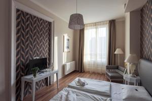 Schlafzimmer mit einem Bett, einem TV und einem Stuhl in der Unterkunft House Octogon in Budapest