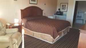 Habitación de hotel con cama y sofá en Denver City Motel en Denver City