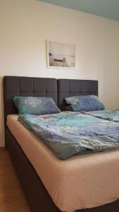 ein großes Bett mit blauer Bettdecke und Kissen darauf in der Unterkunft Apartments Dragi - with pool in Nin