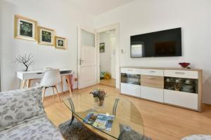 ein Wohnzimmer mit einem Sofa und einem TV in der Unterkunft Apartment Ariana - central & comfy in Poreč
