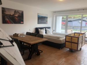 Zimmer mit einem Bett, einem Tisch und einem Bett in der Unterkunft NringRooms Exit-Breidscheid in Adenau