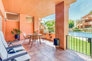 balkon ze stołem i krzesłami oraz basen w obiekcie Hanami La Fragata Garden w mieście Estepona