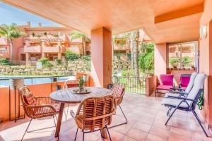 patio ze stołem i krzesłami oraz budynek w obiekcie Hanami La Fragata Garden w mieście Estepona