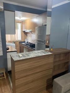 a kitchen with wooden cabinets and a stainless steel refrigerator at Apto centro Gravataí C in Gravataí