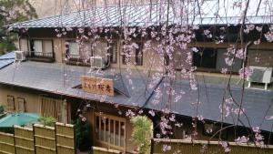 une maison avec des fleurs roses suspendues dans l'établissement Miyoshino Sakuraan, à Yoshino
