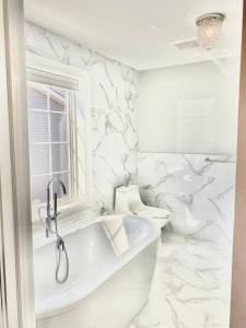 a white bathroom with a tub and a toilet at New Beach house - 3 Blocks to the beach!! in Long Branch