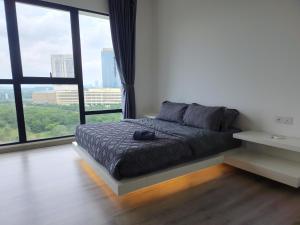a bedroom with a bed with a large window at Mid Valley Southkey Mosaic Cozy Suite at Johor Bahru in Johor Bahru