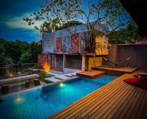 a swimming pool with a deck and a hammock at Royale Riviera Resort Private Pool Villas in Pantai Cenang