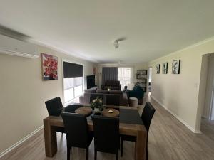 a dining room and living room with a table and chairs at CandE on Wheelton in Kingscote