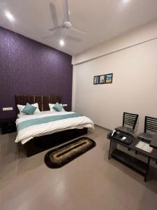 a bedroom with a bed and a purple wall at Wellawing Residency in Ludhiana