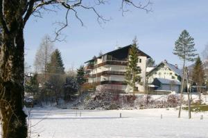 a building in the snow next to a parking lot at Apartment in Bad Mitterndorf - Steiermark 41122 in Bad Mitterndorf
