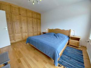 a bedroom with a blue bed and wooden cabinets at Apartment in Sonnenalm - Salzkammergut 37018 in Reith