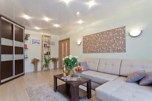 ein Wohnzimmer mit einem weißen Sofa und einem Tisch in der Unterkunft Vip-kvartira Kuzmy Chornogo 4 in Minsk
