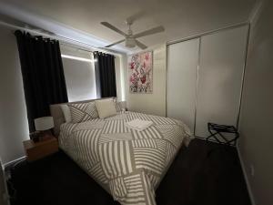 a bedroom with a bed and a ceiling fan at CandE on Wheelton in Kingscote