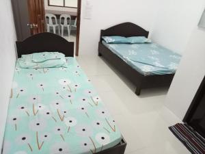 two twin beds in a room with a bedskirts at RGR CAMIGUIN TRAVEL TOUR SERVICES AND PENSION HOUSE in Mambajao
