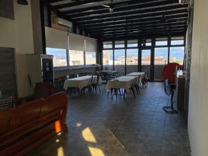 una sala da pranzo con tavoli, sedie e finestre di Mr.Lee a Ji'an