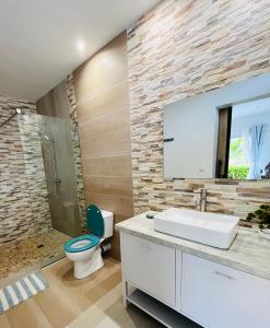 a bathroom with a white sink and a toilet at COCODY ROC in Ambohidratrimo