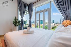 a bedroom with a large window with a white bed with a box on it at Son&Henry Sailing Tower in Ho Chi Minh City