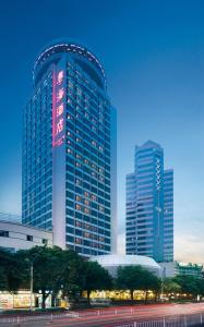 un grand bâtiment avec un panneau sur son côté dans l'établissement Guangdong Hotel (Zhuhai), à Zhuhai