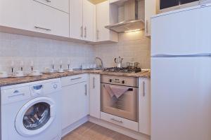 eine Küche mit einer Waschmaschine und einem Kühlschrank in der Unterkunft Vip-kvartira Kuzmy Chornogo 4 in Minsk