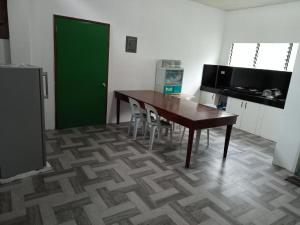 una cocina con mesa y sillas y una puerta verde en RGR CAMIGUIN TRAVEL TOUR SERVICES AND PENSION HOUSE, en Mambajao