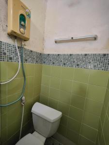 y baño de azulejos verdes con aseo y ducha. en 74 Guest House Haad Rin, en Haad Rin