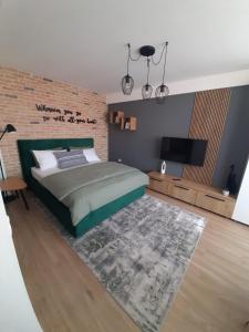 a bedroom with a large bed and a brick wall at City Center View Studio Apartment 1 in Timişoara