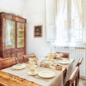a dining room with a table with dishes on it at casa Guido Reni in Bologna