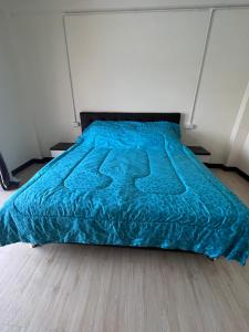 a bed with a blue comforter in a bedroom at Sea skyline home in Sattahip