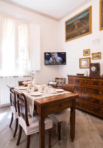 uma sala de jantar com uma mesa de madeira e cadeiras em casa Guido Reni em Bolonha