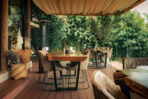 un patio con mesas y sillas en una terraza de madera en TEVA Glamping & Retreat, en Rionegro