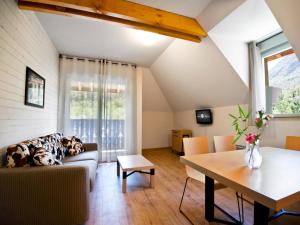 a living room with a couch and a table at Lagrange Vacances Les Chalets d’Ax in Ax-les-Thermes