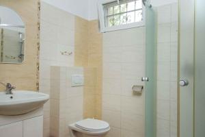 uma casa de banho com um lavatório, um WC e uma janela. em Holiday Homes in Balatonboglar 40843 em Balatonboglár