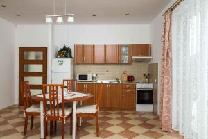 uma cozinha com mesa e cadeiras e uma cozinha com frigorífico em Holiday Homes in Balatonboglar 40843 em Balatonboglár
