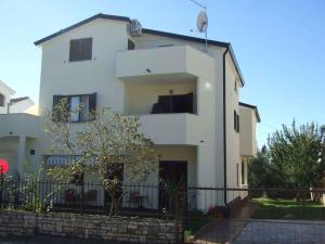 una casa blanca con una valla delante en Apartment in Novigrad - Istrien 9815, en Karpinjan