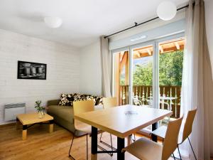 ein Wohnzimmer mit einem Tisch und einem Sofa in der Unterkunft Lagrange Vacances Les Chalets d’Ax in Ax-les-Thermes