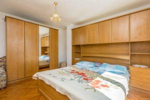 a bedroom with a large bed with wooden cabinets at Apartment in Skrpcici - Insel Krk 41816 in Skrbčići