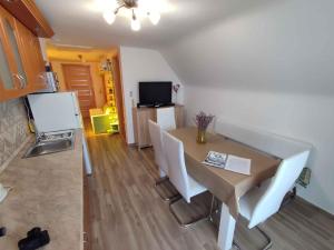 une salle à manger avec une table et des chaises blanches dans l'établissement Apartment in Fonyod - Balaton 43602, à Fonyód